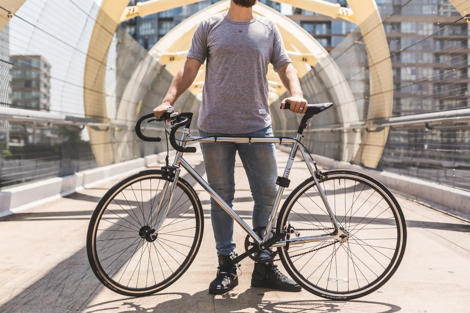 Silberner metallischer Rahmen Fixie-Fahrrad mit schwarzen Lenker, Reifen und Sattel.